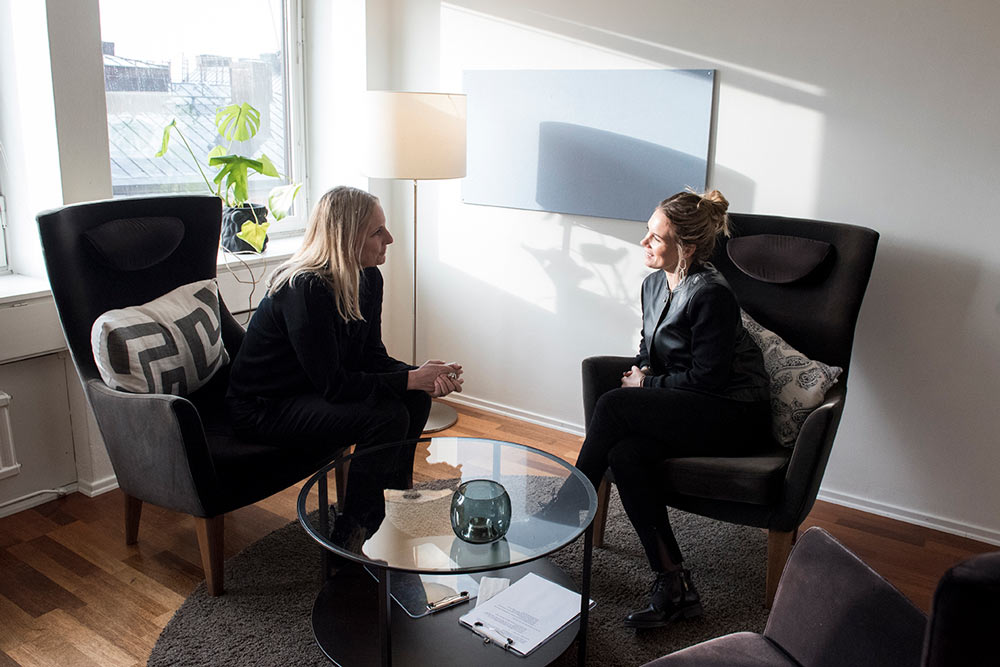 Två personer samtalar i fåtöljer